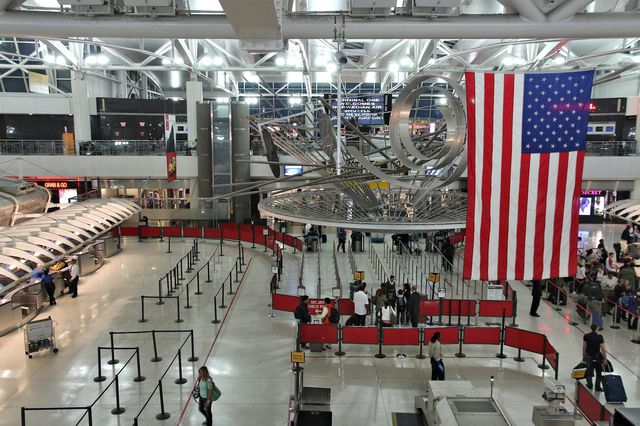 A large American flag hangs from the rafters inside JFK International Airport in NYC.